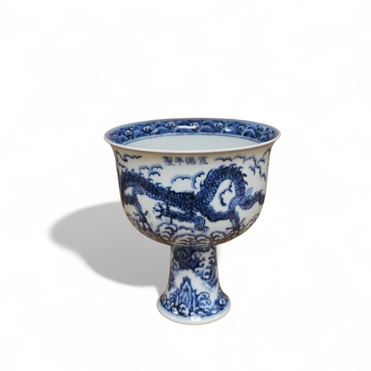 A Chinese blue and white stem bowl, painted with dragons in underglaze blue, 18cm high